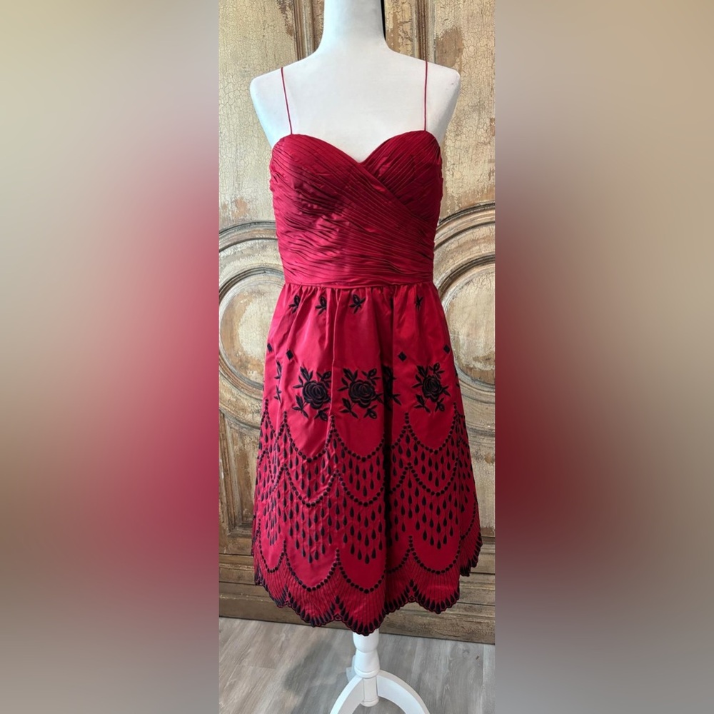 Red taffeta & black embroidery dress with black sash belt.